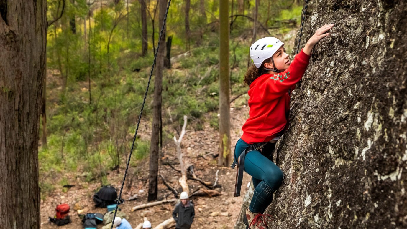 Climber at the Mt Barney Lodge beginner's rock climbing site.