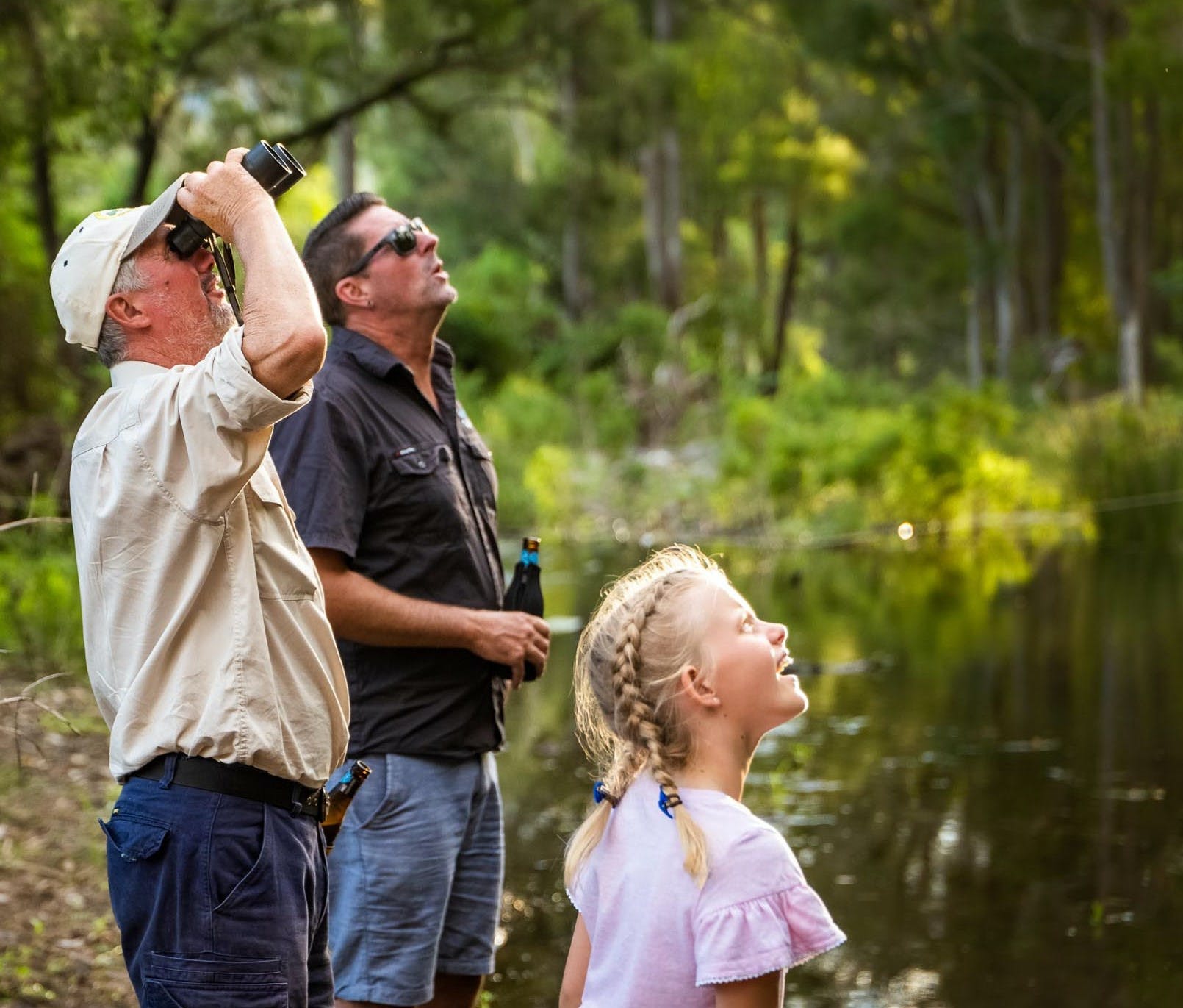 Don't forget the binoculars! A group of people looking through binoculars to see birds.