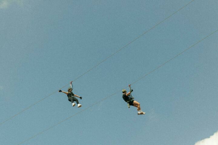 Image of two adventurers ziplining in the overhang tour